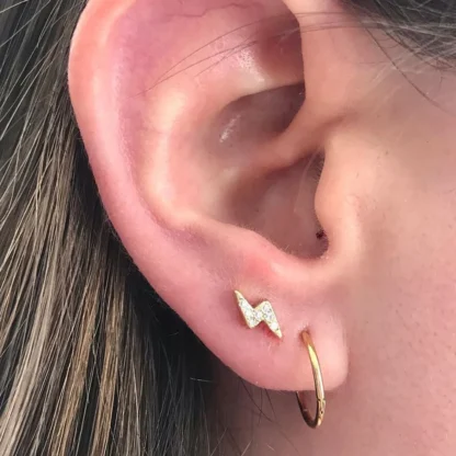 Piercing Raio Titanio Com Zirconia Dourado na Pele